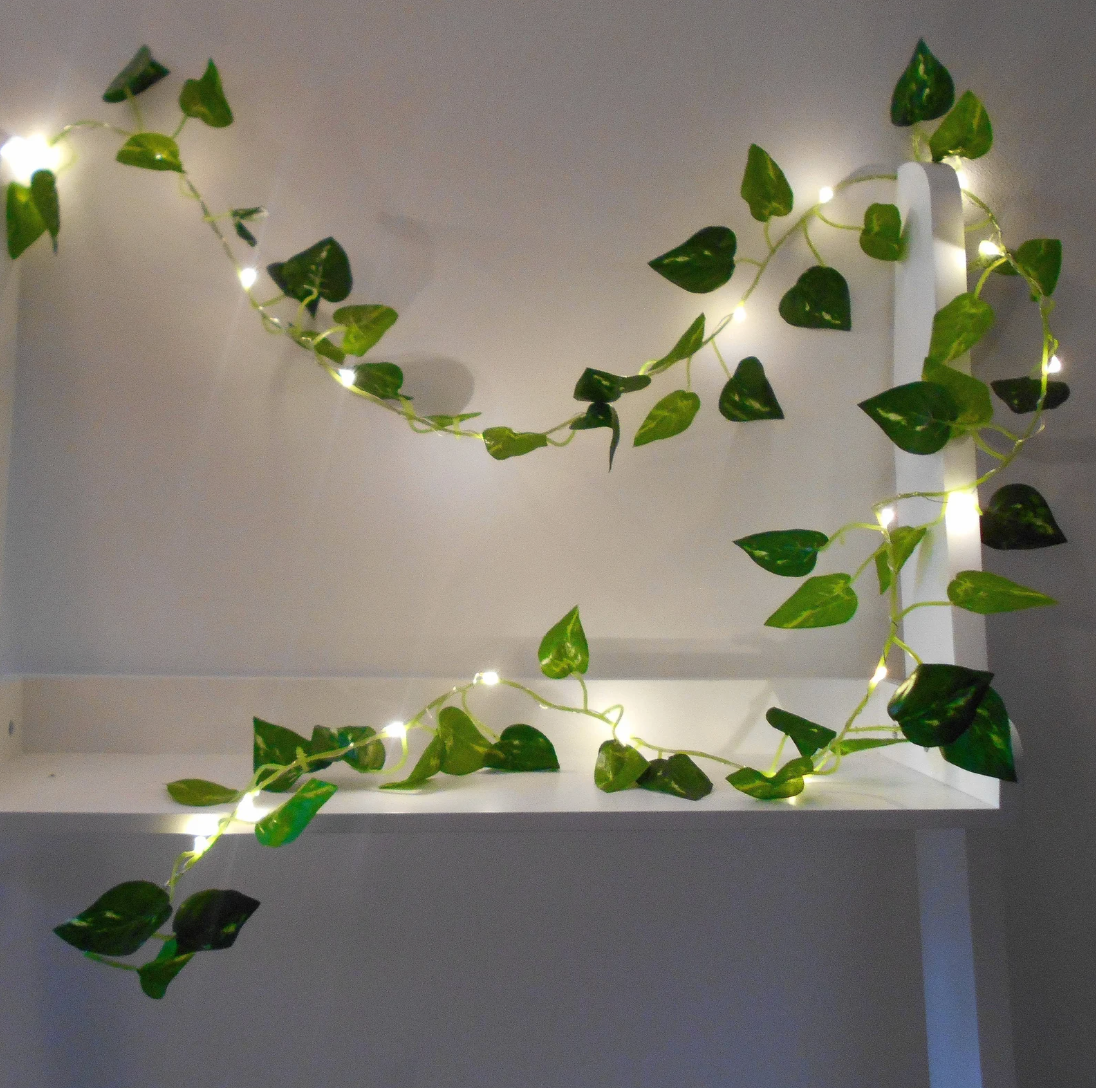 Ivy garland with LED lights intertwined on a white shelf