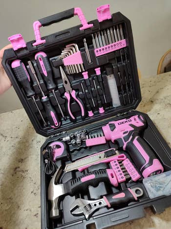 Pink instrumentality   kit with drill, hammer, pliers, screwdriver set, and more, organized neatly successful  a achromatic  carrying case