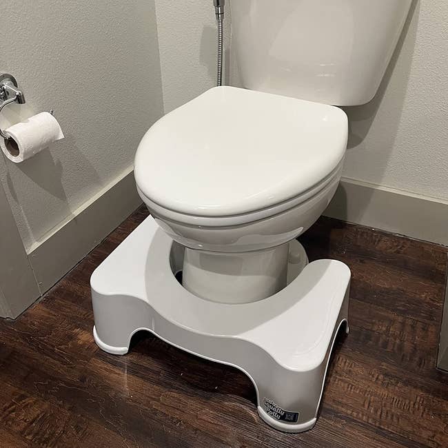 reviewer's squatty potty in front of a toilet