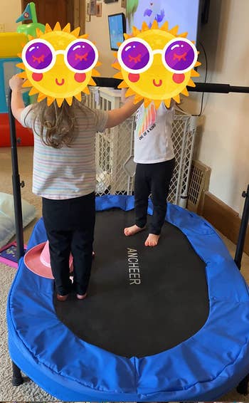 reviewer's photo of their twins jumping on the trampoline