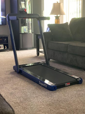 reviewer photo of their blue and black treadmill folded up