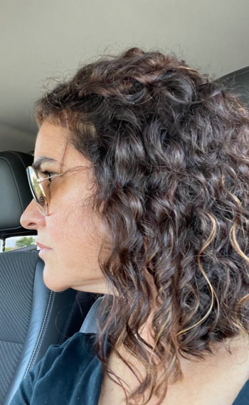 side view of reviewer with curly moisturized looking hair
