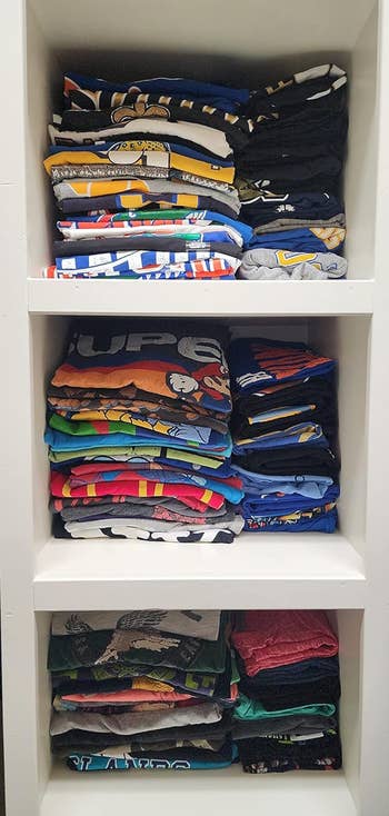 A reviewer's shirts folded neatly in a shelving unit after using the folding board