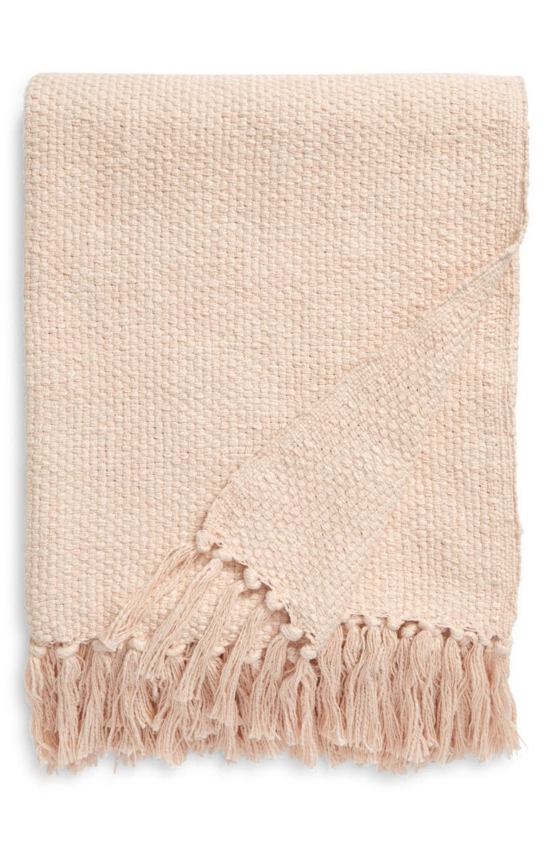 light pink woven blanket with fringe on the ends