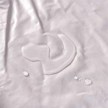 Mattress protector (without sheet) with puddle of water