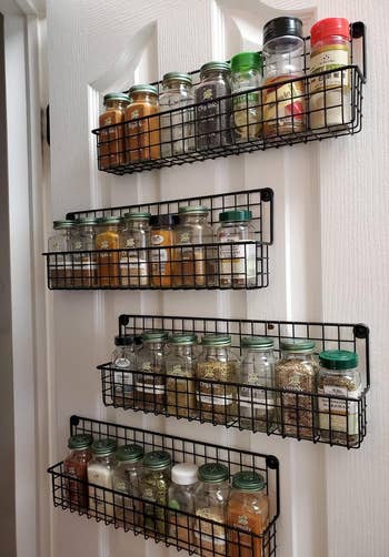 reviewer's four spice racks hanging on pantry door