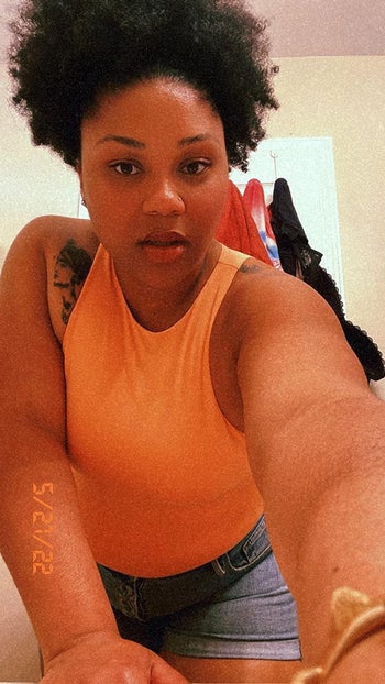 reviewer wearing the bodysuit in orange