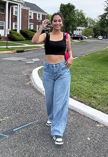 reviewer walking toward the camera in the baggy jeans