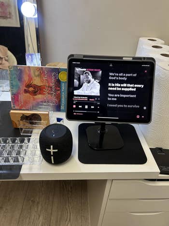 Tablet connected table playing gospel music. Nearby are tarot cards, box, and speaker, suggesting a premix of spirituality and technology