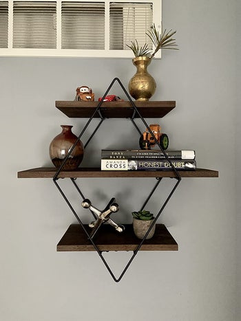 reviewer image of the coffee-colored floating shelf mounted to a wall