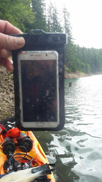 A reviewer showing their phone inside the phone case, which they pulled out of water