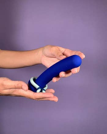 Model holding blue dildo with green cock ring (not included)