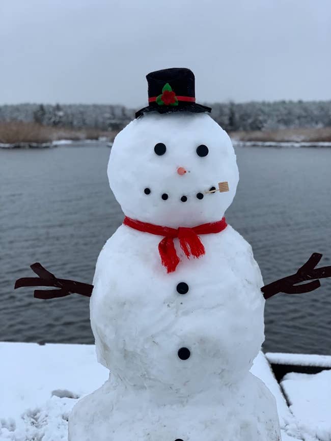 a reviewer's snowman accessorized with items from a snowman building kit