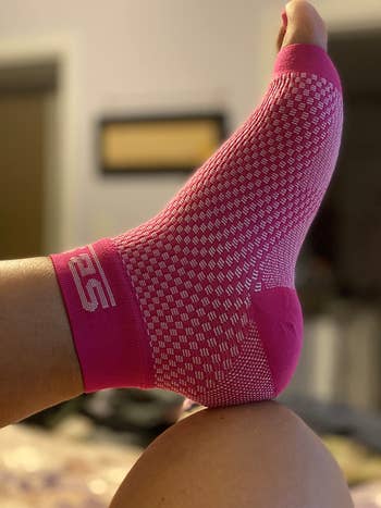 reviewer wearing the pink compression sock