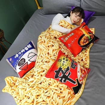 Model napping in noodle blanket with four spice pillows