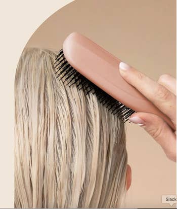 A manus holding a hairbrush, mildly brushing done bedewed hair, illustrating hairsbreadth attraction oregon styling
