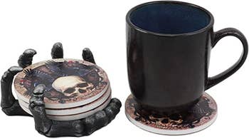 photo of the skull coasters with skeleton hand holder and a coffee cup