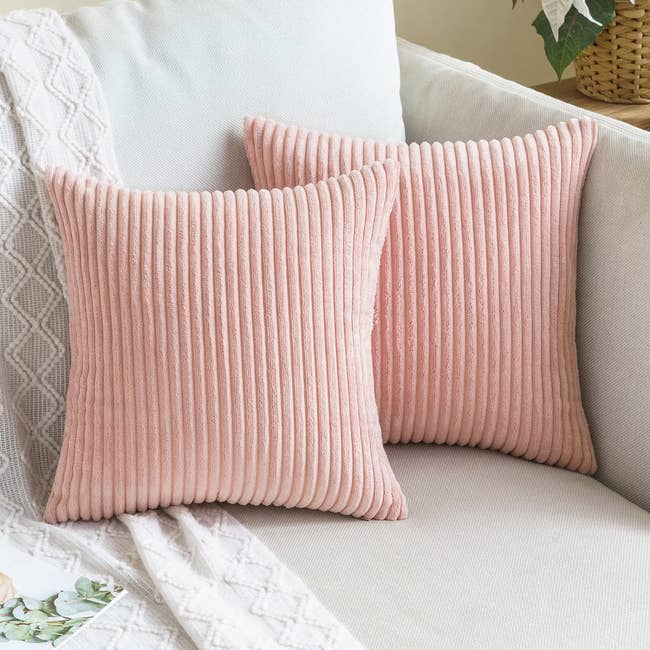 Two pink corduroy throw pillows on a couch