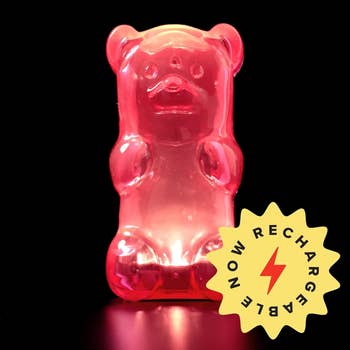 Gummy bear-shaped lamp with a 'Recharge Me' sticker on a glossy surface. Great for whimsical home decor
