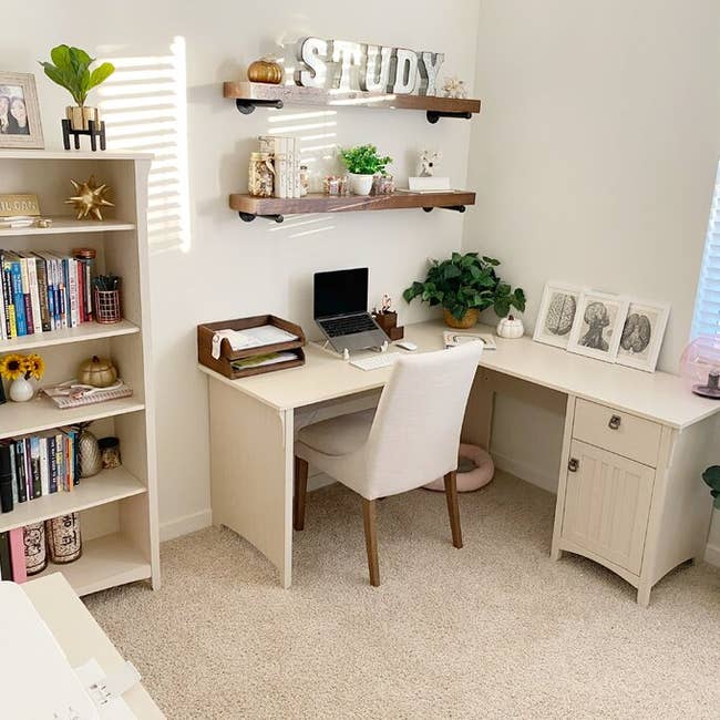 a white l shaped desk with a cabinet and drawer at one end