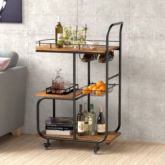 the industrial bar cart with bottles on each of its three tiers