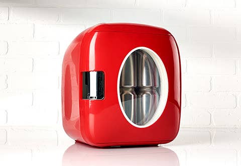 a red mini fridge with glass oval center