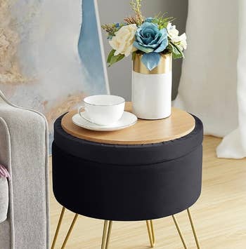 The black ottoman with the top flipped ever to show its tabletop