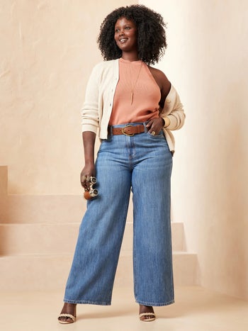a model posing in wide leg blue jeans