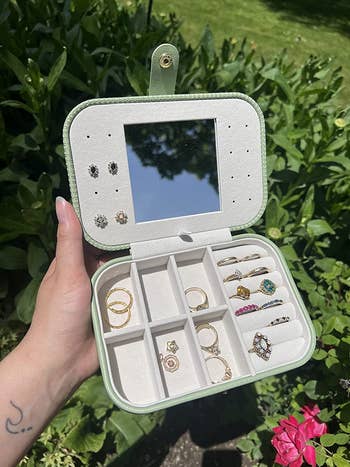 reviewer photo holding green jewelry case out in the sun