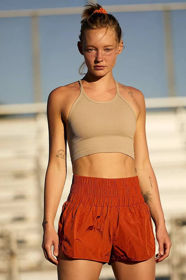 model wearing the high-waisted shorts in a rust color