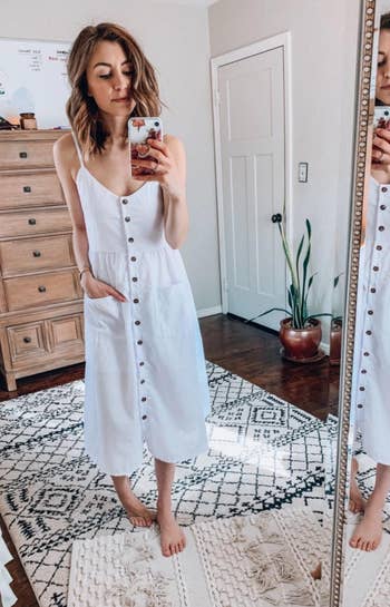 reviewer wearing the dress in white, with hands in the pockets