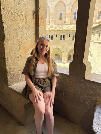 Person successful  casual summertime  outfit sits successful  a chromatic  archway wrong   a historical  building
