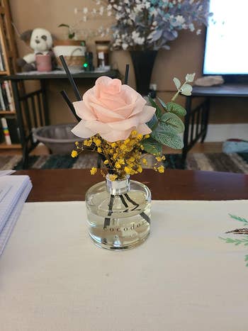 A small floral arrangement or a rose and yellow baby's breath