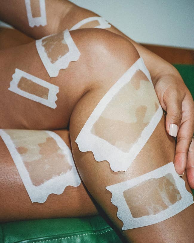 Person with wax strips applied to legs