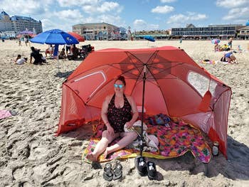 reviewer using the orange umbrella at the beach