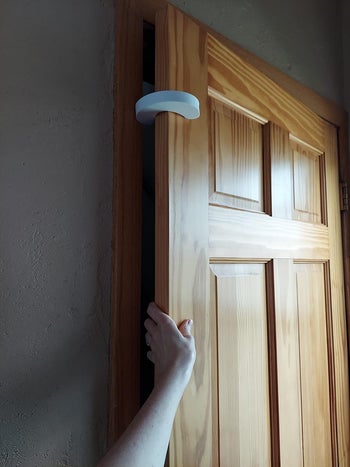 same reviewer showing that their adult-sized hand fits in the gap