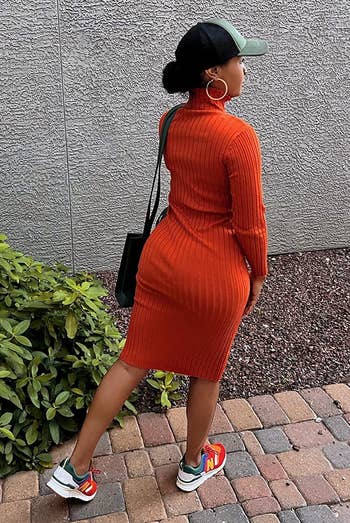 reviewer wearing the orange ribbed sweater dress