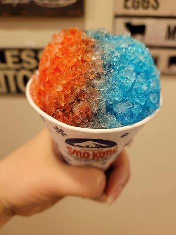 A reviewer holding a snow cone made using the machine
