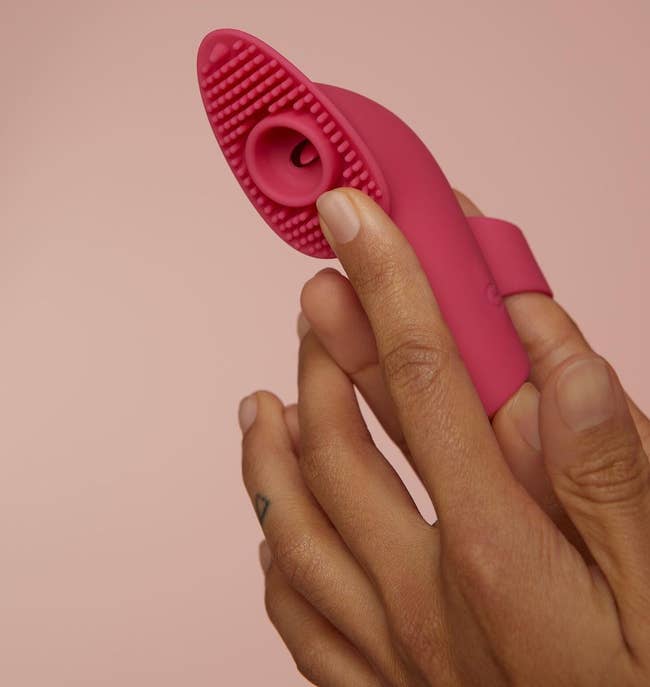 Model holding pink finger vibrator with silicone rods
