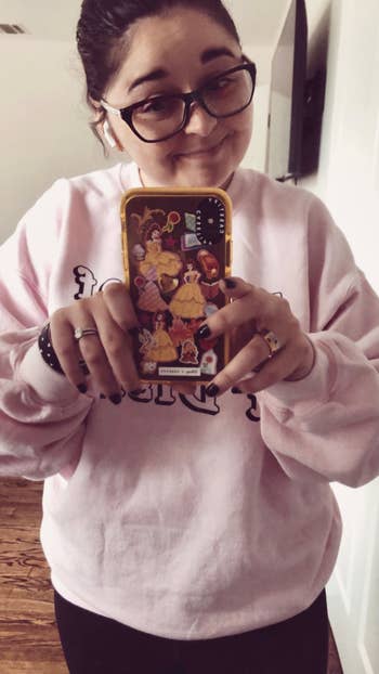 a photo of buzzfeed editor holding the belle phone case