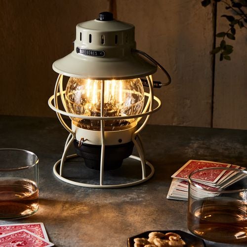 edison bulb railroad lantern next to deck of cards on table