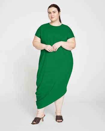 Woman posing in a green dress, suitable for plus-size fashion article