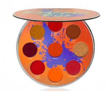 Petri dish-shaped eyeshadow palette with various orange, red, and pink shades