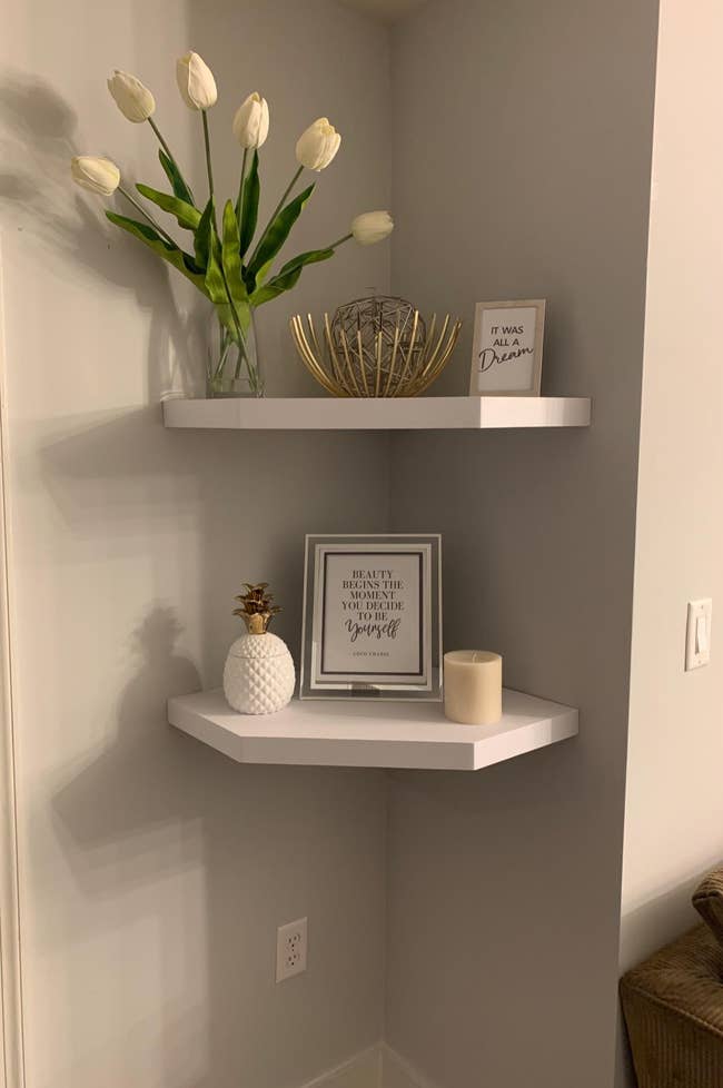 Reviewer image of white floating corner shelves with plants and frames on each one