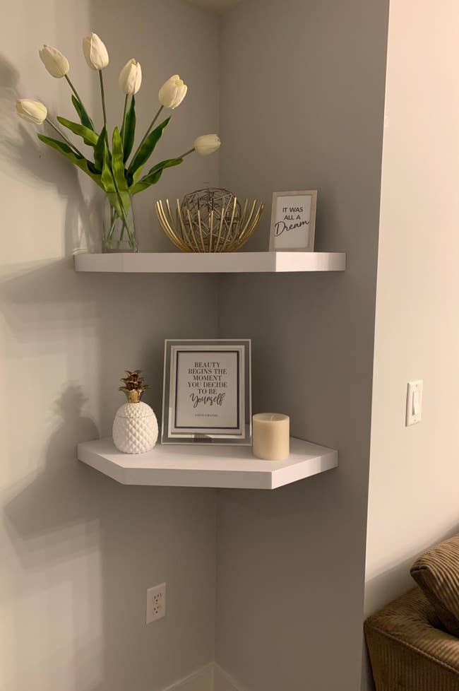 Reviewer image of white floating corner shelves with plants and frames on each one