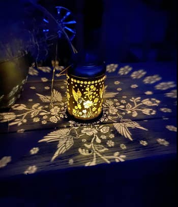 Ornate lantern projects intricate floral patterns connected  a woody  surface, creating a cozy and creator  ambiance