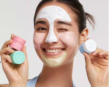 Model holding up all three face masks with sections of them on her face 