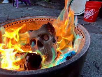 A skull-shaped occurrence  log is burning with agleam  multicolored flames successful  a occurrence  pit