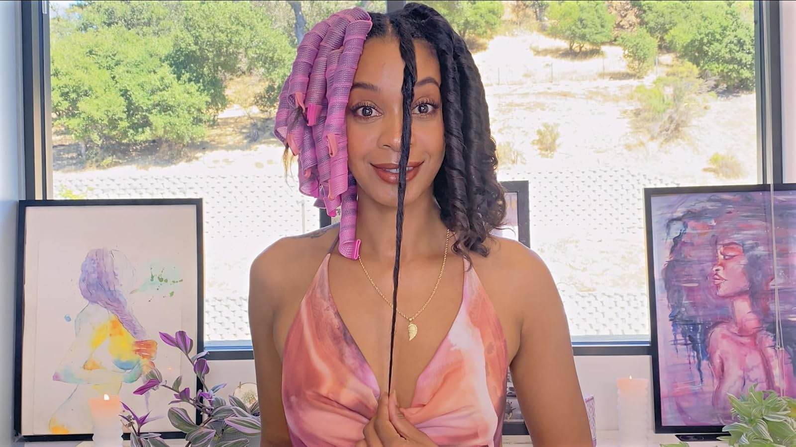 Reviewer demonstrates hairsbreadth  curling method  with pinkish  rollers