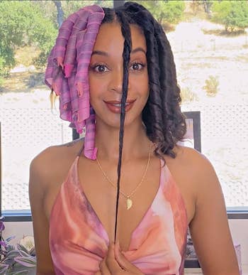 Reviewer demonstrates hairsbreadth curling method with pinkish rollers
